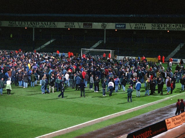 Evacuated PNE fans from the Town End stand during the first half of the match against Wrexham was disrupted by a small fire. - fans on the pitch - preston north end fire - March 1997