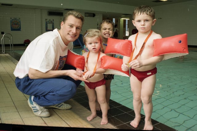 More than 600 Preston swimmers took the plunge to raise cash for the Olympics. Swimmers young and old waded in to make more than £6,000 for the British Olympic Association. Picture shows Olympic silver medalist Nick Gillingham giving medals to three young swimmers. From left are Mairi McGilverary, two, Jason Watson, three, and Hugh McGilveray, four