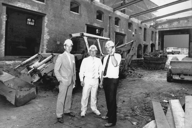 Alan Douglas (director) with Eddie Rimmer and John Carter (site managers) of Oakwood Construction, who were undertaking work at Cotton Court, Church Street, Preston in 1989. They are pictured in front of the old police horse stables. You can just about make out the top half of the old wire works in the background