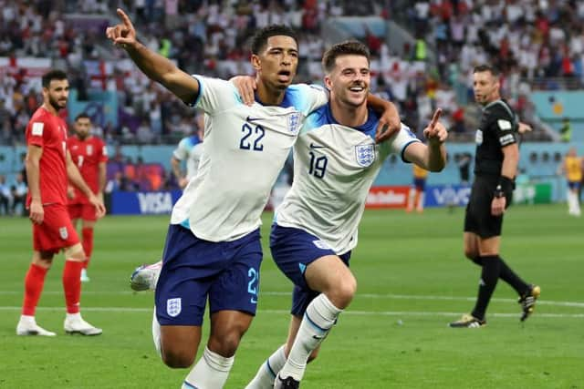 England's Jude Bellingham (left) celebrates opening the scoring against Iran with Mason Mount Picture: Clive Brunskill/Getty Images)