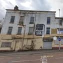 Victoria Furniture & Carpet Warehouse: Still displaying the classic but fading old sign on the side of a building which reads Victoria Furniture & Carpet Warehouse, this building has been boarded up for a while, with the paint also flaking heavily.
