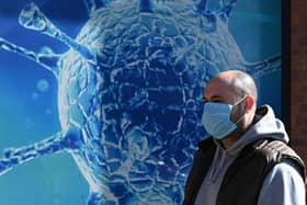 A man wearing a mask walks past the Regional Science Centre in Oldham (Photo: OLI SCARFF/AFP via Getty Images)