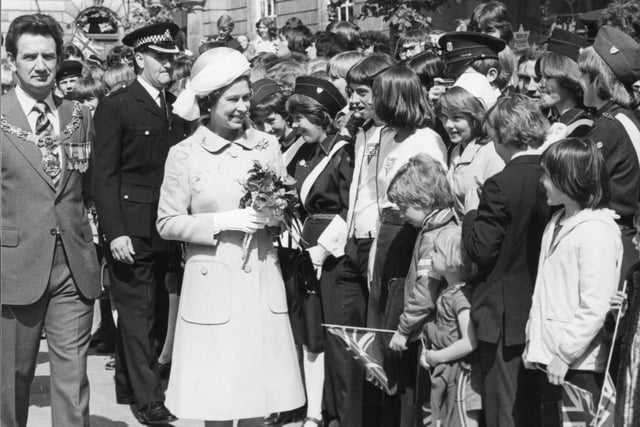 A mixed group of children, including some Girl Guides, gather for a chat with Her Majesty in 1977