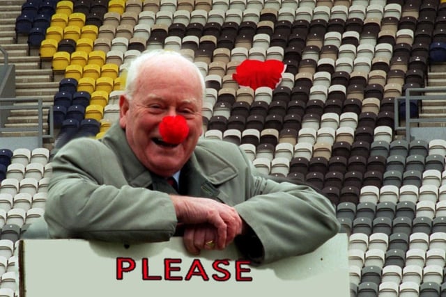 Tom Finney stood in front of the Tom Finney Stand at Deepdale Football Ground, both sporting red noses for Comic Relief