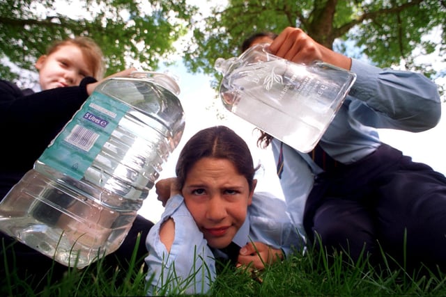 Water juggling... Helen Cheadle puzzles over how to put a quart in a pint pot with a little help from Stacey Brown, left, and Shabana Ejaz, when maths lecturers from St Martins College, Lancaster, visited Archbishop Temple School, Fulwood, Preston