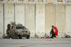 A Taliban Badri special force fighter runs while carrying a blanket at the airport in Kabul on August 31, 2021, after the US pulled all its troops out of Afghanistan
