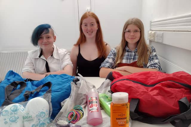 From left: S.A.F.E. members Bailey Bird, Lucy Cashin and Sarah Clarke with some of the products provided in the care bags