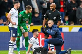 Preston North End's Andrew Hughes receives treatment alongside Greg Cunningha, Freddie Woodman and referee Sam Allison