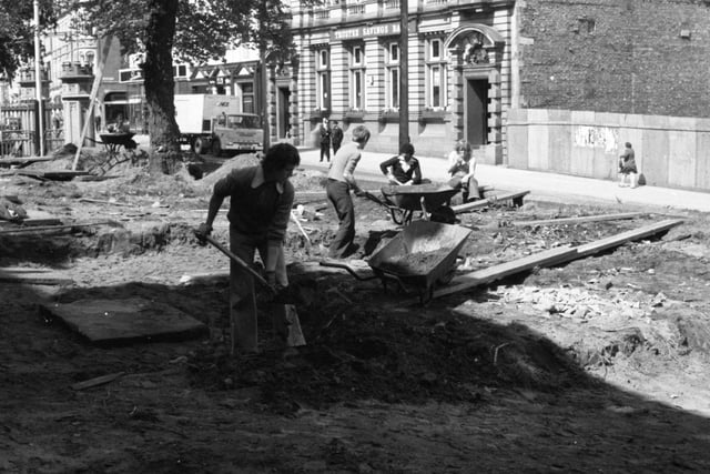 Men employed through the Government's job creation programme digging up ancient tombstones in the grounds of Preston's Parish Church, to make way for landscaped gardens