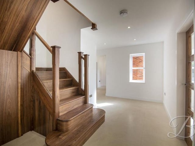 One of the tantalising features of the house is this stunning, solid walnut staircase, fitted with a glass balustrade.