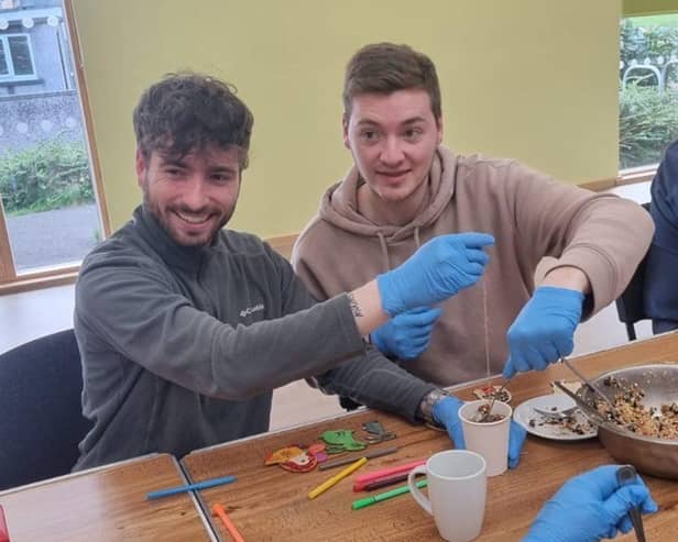 A Westmorland Homecare staff member (left) with a client, making a bird feeder at a client social