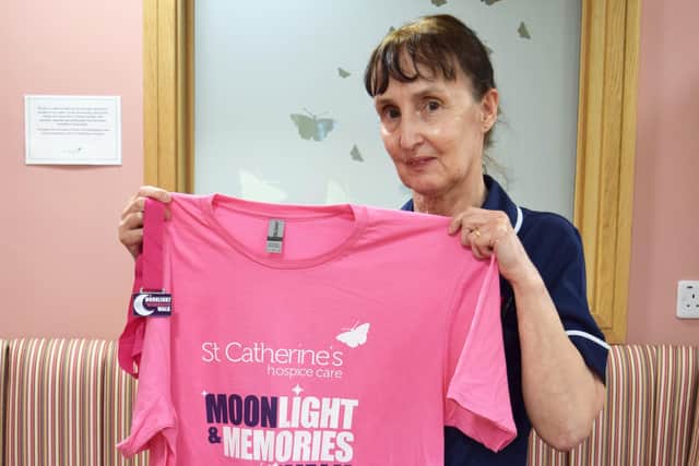Sister Barbara Sutton holds up a Moonlight and Memories T-shirt