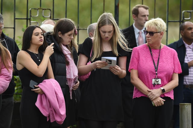 Mourners at the funeral weraing "a splash of pink"