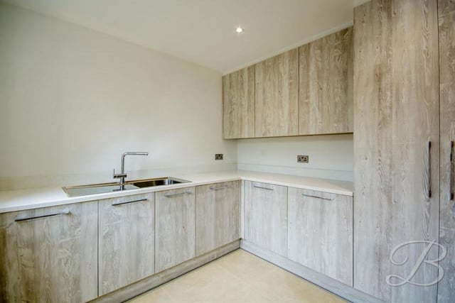 Just off the kitchen is this handy utility room, complete with modern cabinets and units, providing lots of storage space. There is also an inset sink and drainer, plus a work surface.