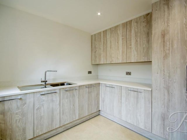 Just off the kitchen is this handy utility room, complete with modern cabinets and units, providing lots of storage space. There is also an inset sink and drainer, plus a work surface.