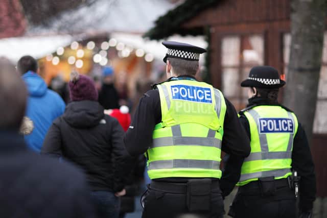 Police in hi-visibility jackets policing crowd control at a UK event.