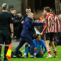 A member of the North End medical team tries to treat Brad Potts while Sunderland's Dennis Cirkin complains (photograph: Alex Dodd/CameraSport)
