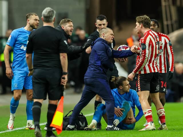 A member of the North End medical team tries to treat Brad Potts while Sunderland's Dennis Cirkin complains (photograph: Alex Dodd/CameraSport)
