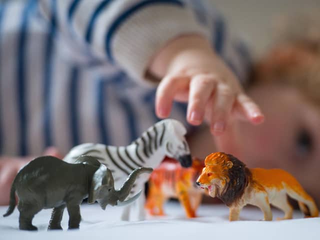 A preschool age child playing with plastic toy animals. Dominic Lipinski/PA Wire