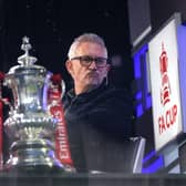 Gary Lineker sits in the BBC Studio next to the FA Cup