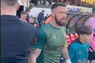 Vinnie pictured entering the football pitch with Chorley goalkeeper Matt Urwin.