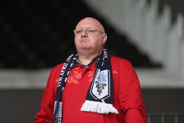 A PNE fan adorned in his club scarf looks resolute looking out onto the pitch at Fulham.