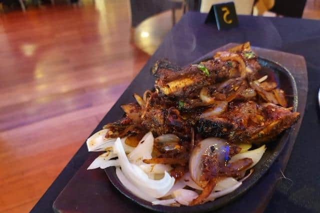 Lamb chops arrived on a sizzling platter along with fried onions in a hot marinade