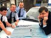 Peter Taylor from the Preston and North Lancashire Blind Welfare Society eventually smiled when the local police (left to right) Inspector Mark Tottman, Community Officer for the Kingsfold area Peter Rigby and Sgt. Alan Roberts from Penwortham Police Station took the handcuffs off and presented him with a cheque for 550 raised at a recent 60s and 70s night 
