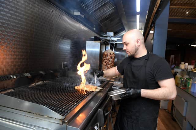 Efthymis was the first in the family to move to Preston, coming in 2015 to begin a Computing degree at UCLan. Above he is pictured in the kitchen at Greekouzina.