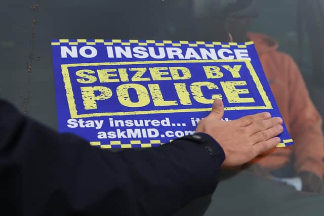 A sticker is placed on the windscreen of an uninsured car after it is seized by police.