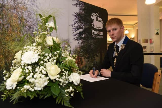 Preston Mayor Coun Neil Darby signs the Town Hall's book of condolence.