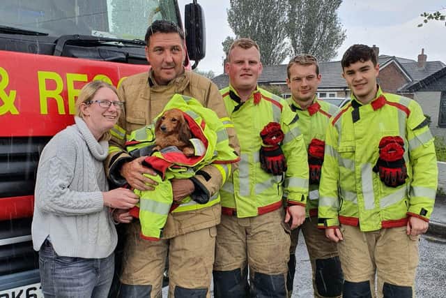 Rachael Lucas from Chorley with the fire men who rescued her four-year-old dachshund Roxy