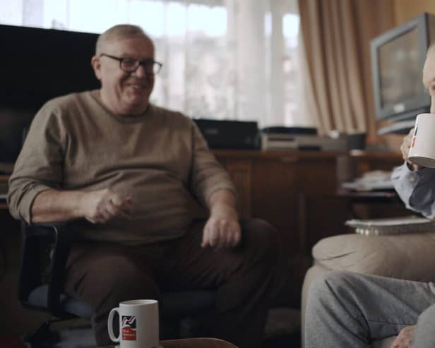 Volunteer Liam (left) with blind veteran Ken enjoying a cup of tea and a chat. Photo:  Blind Veterans UK