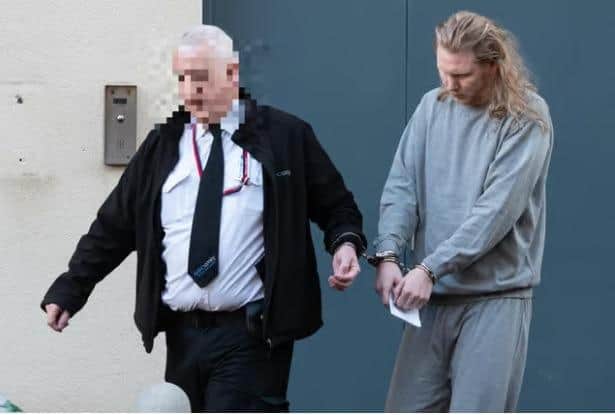 Godkin is led away to a prison van after his first appearance in court in January.