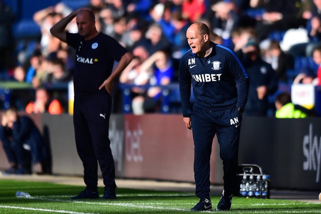 Preston North End manager Alex Neil reacts with Wigan boss Paul Cook in the background
