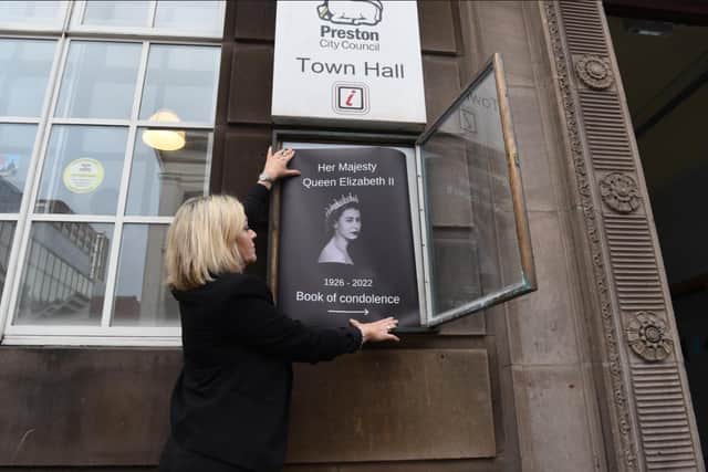 Alma Stewart puts up posters outside Preston Town Hall to direct people to the council's book of condolence.
