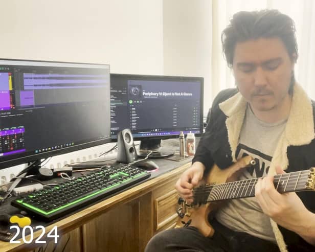 Rhys playing guitar at his home inPreston (2024)