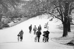 This group of hardy cyclists and pedestrians are making their way up a snowy hill on Avenham Park in Preston. The image was taken in 1983