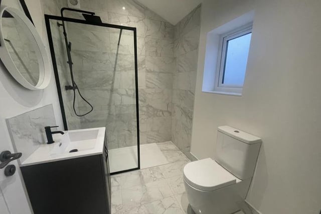 The shower room oozes style. It is fitted with a contemporary suite, comprising walk-in shower enclosure, wash hand basin set in a vanity-style unit, low-flush WC and ladder-style radiator. The floors and walls are tiled.
