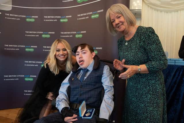 Chorley teenager Alex Macpherson, 16, who suffers with cerebral palsy, has been presented with a British Citizen Youth award for his fundraising of over £16,000 for young people's charity Rainbow Hub. He is pictured with singer Kimberley Wyatt (left) and Dame Mary Perkins (right)