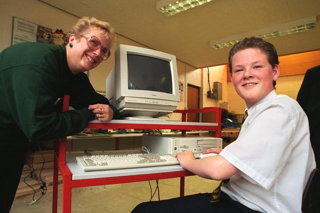 Christopher Ekins, 13, a pupil at Broughton High School, Preston, uses a computer handed over by Gill Davies of Asda. The school collected tokens from Asda