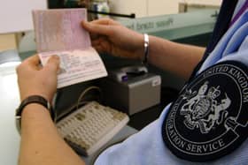 An immigration officer checking a passport at Heathrow Airport.
