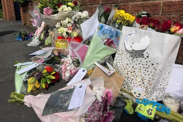 Flowers, balloons, drawings and photographs - including this touching tribute from Layton's birth mum Stacey Bailey - left where the tragedy unfolded in Bilsborough Hey, Kingsfold, Penwortham on Tuesday, August 1.