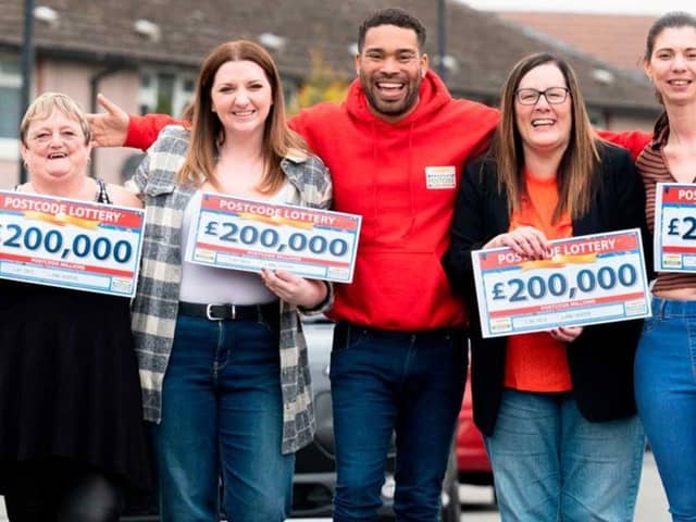 Danyl Johnson from People's Postcode Lottery with some of the lucky Lancaster winners, Isobel, Ria, Sara and Amie.