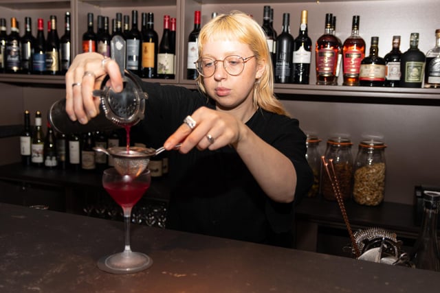 Bar Tender Meg Kelly making a cocktail.