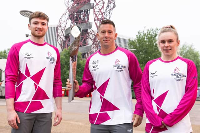 Batonbearers and Team England divers, Matty Lee MBE, left, and Robyn Birch hand the Queen’s Baton to Jonathon Silman in London