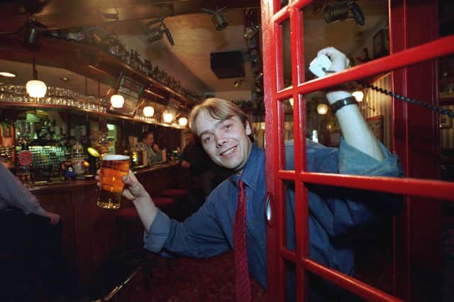 Ringing for last orders, Tim Worthington, the manager of the Red Lion pub in Longton near Preston, in the red phone box inside the pub