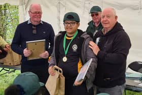 Qais being presented with his Fishing Achievement Medal by Duncan Smith and Harry Cox