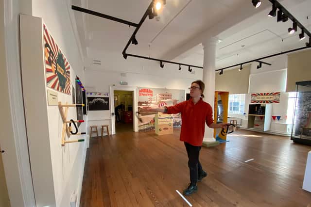 Lancaster City Museum's site supervisor, Alex Hale, tries out the hoopla in the interactive section of the Morecambe exhibition.