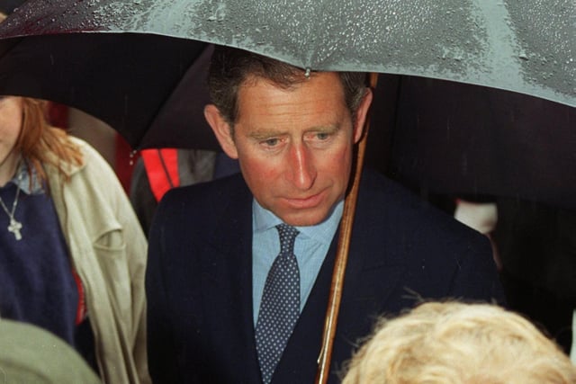 The rain poured down as this picture of Prince Charles under an umbrella shows